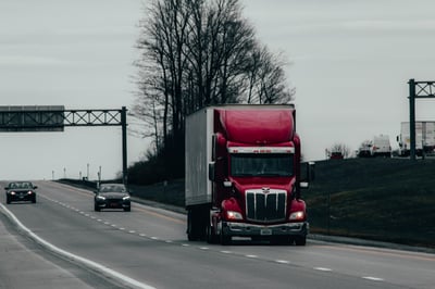 Red and white truck on road during daytime from Unsplash